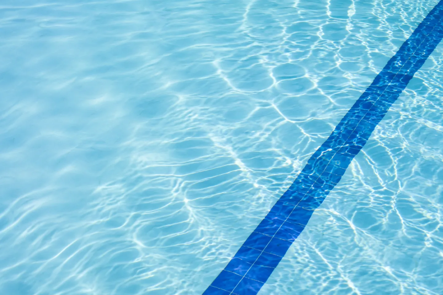Sunlight moving across clear blue pool water